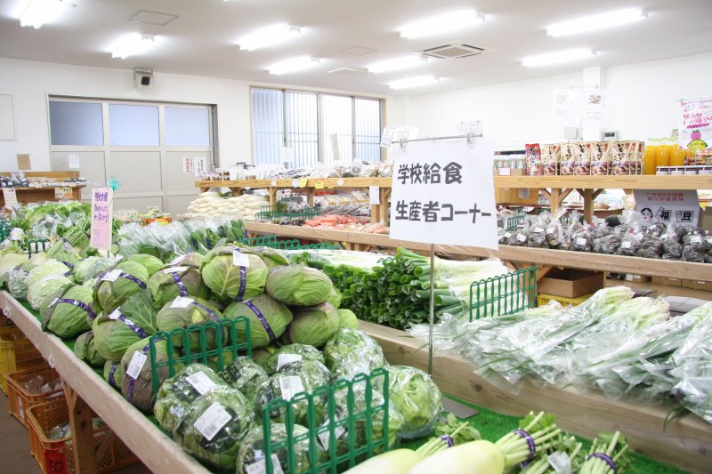 学校給食生産者コーナーには、学校給食にも使われる無農薬で新鮮な野菜がずらりと並ぶ。安心して食べられる野菜に訪れた人は次々と手を伸ばす。